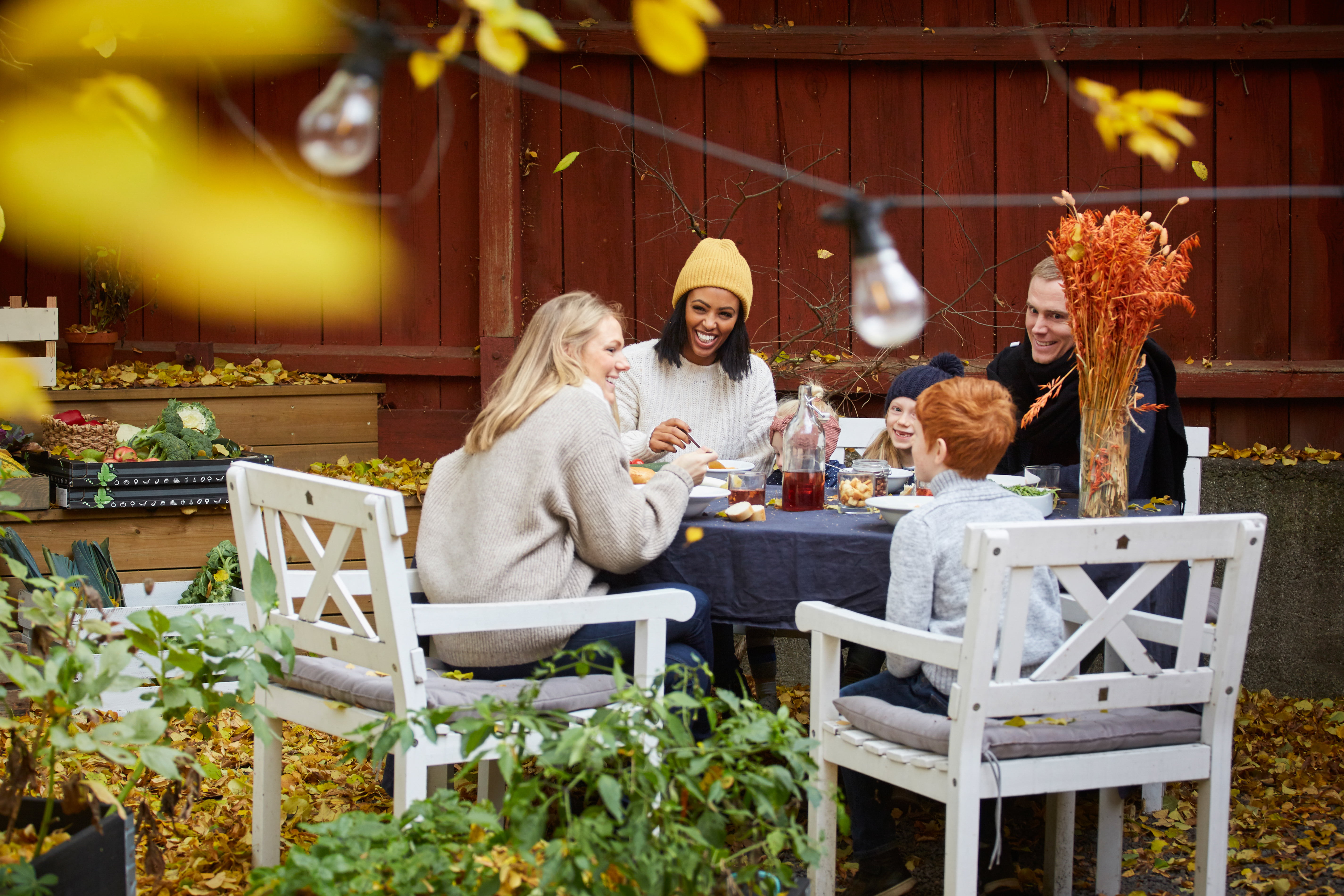 Familie som sitter utendørs og spiser middag
