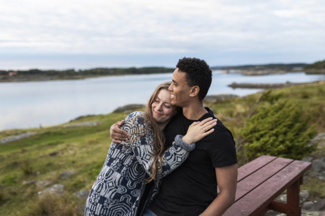 Par som holder rundt hverandre på stranden