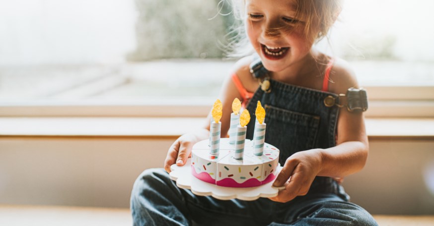 Jente som blåser ut lys på kake